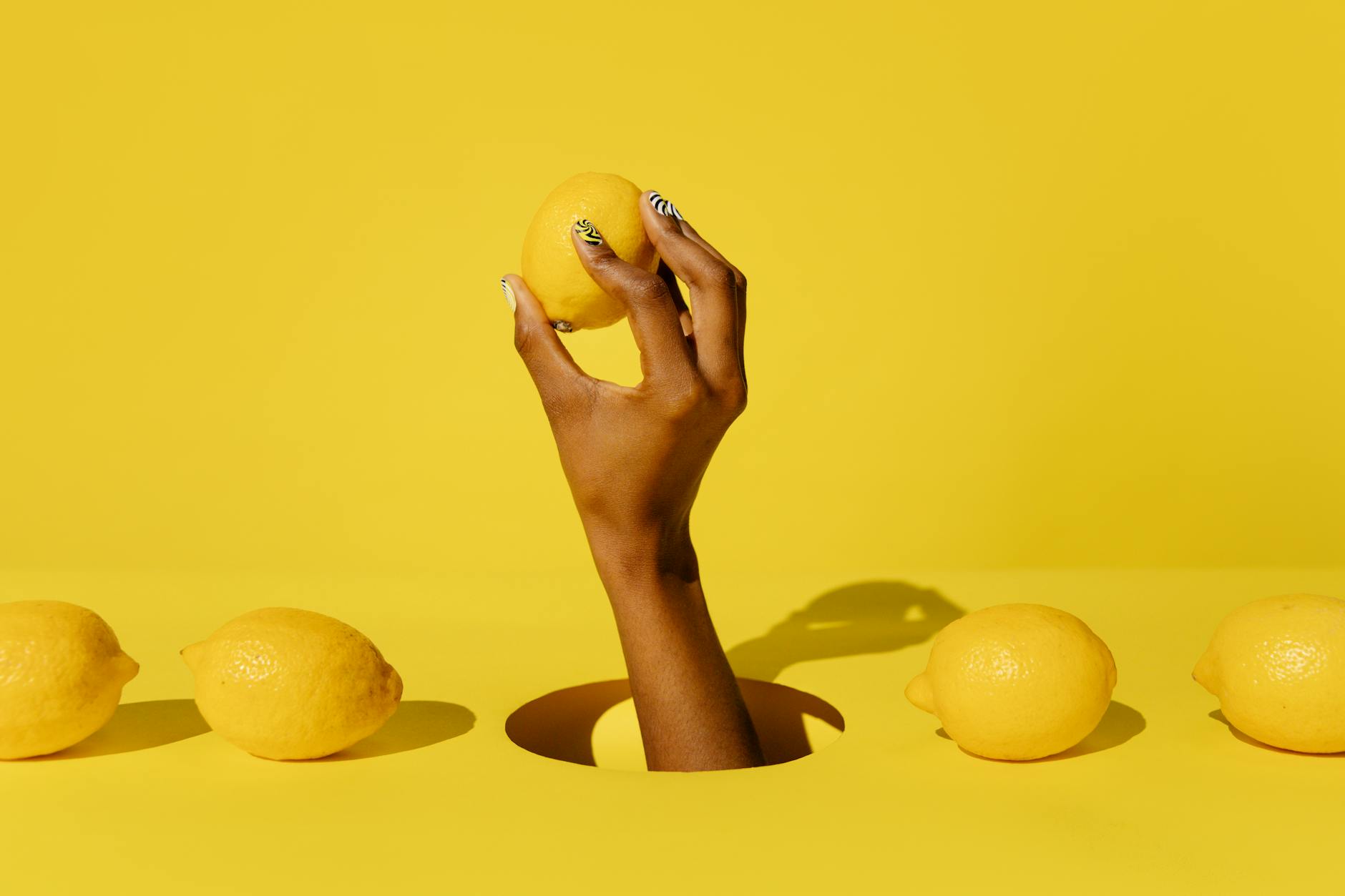 Yellow silicone vibrator surrounded by fresh produce on a bright background