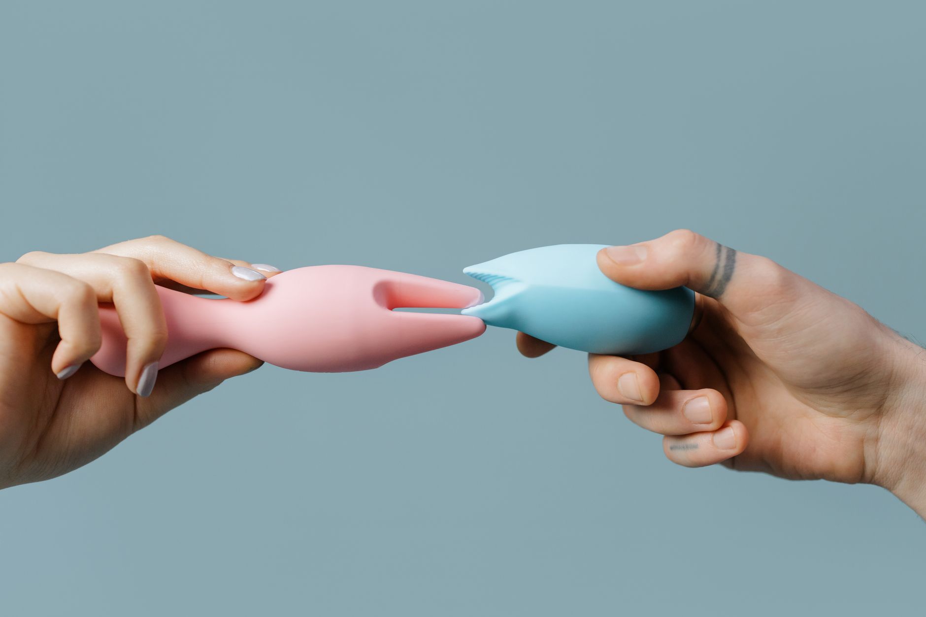 Hands holding pastel-colored silicone toys in a calming arrangement